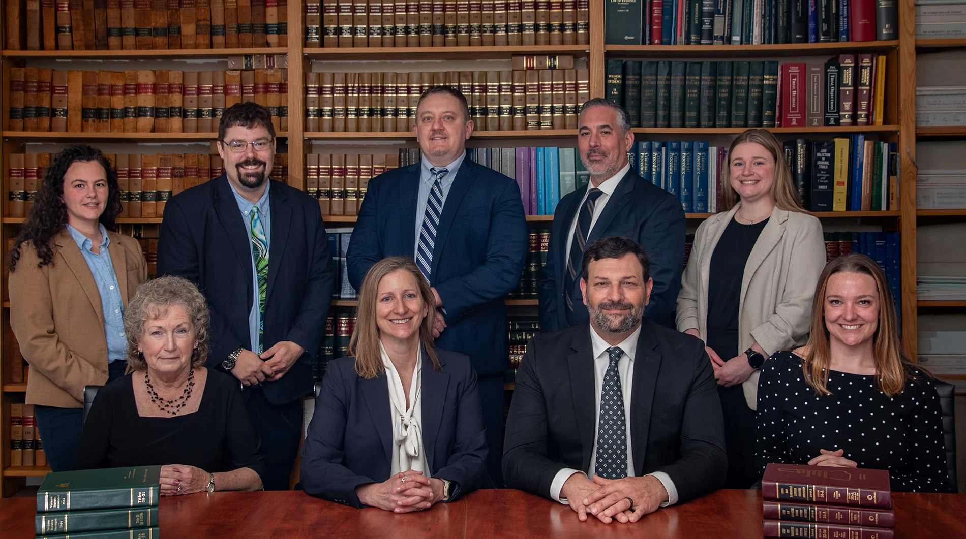 Marsicovetere & Levine Law Group team in a law library with books.